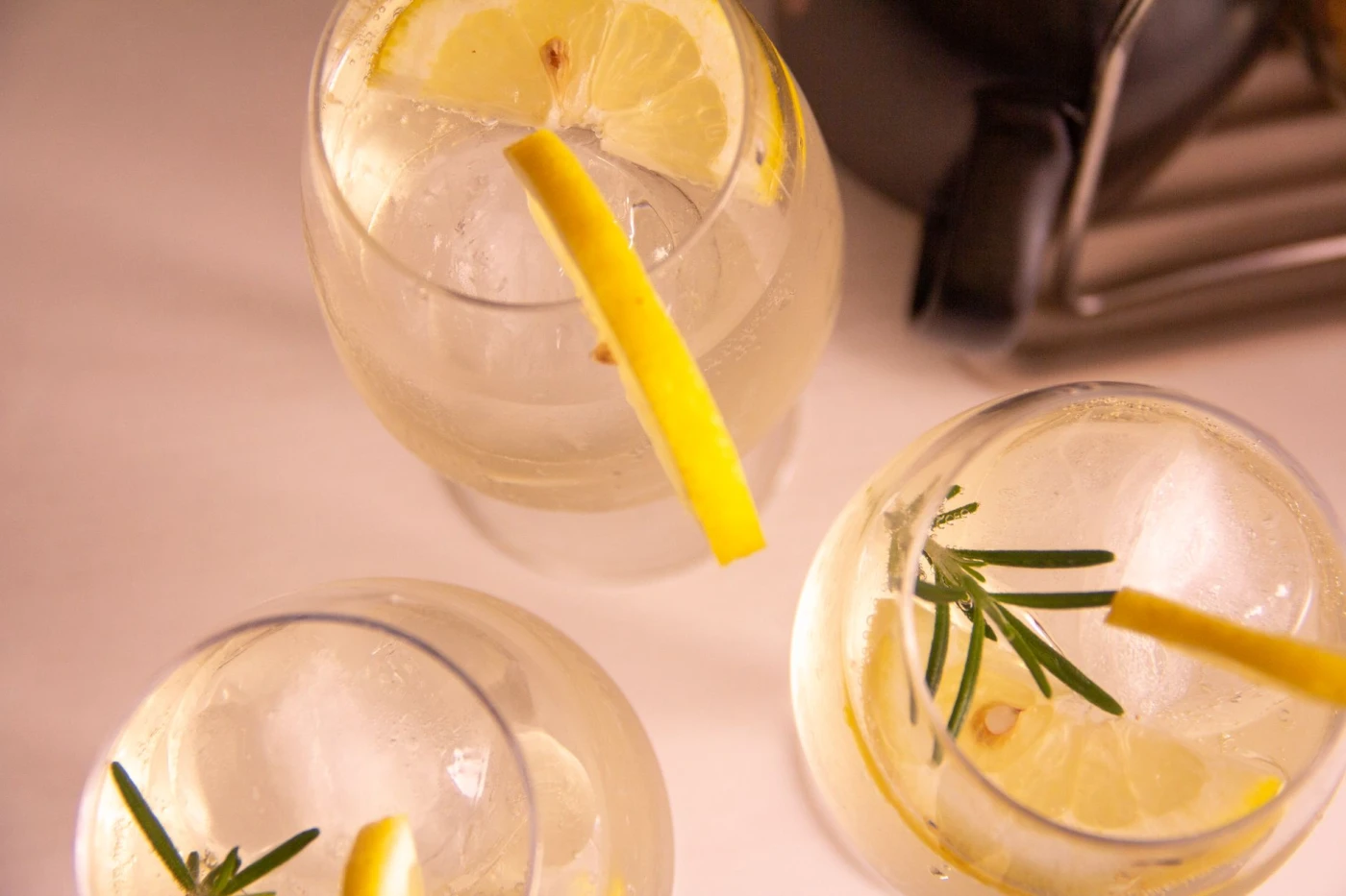 10 Cocktails to Make with Lillet Blanc: A top-down view of lemon and rosemary cocktails in glassware with a refreshing vibe.