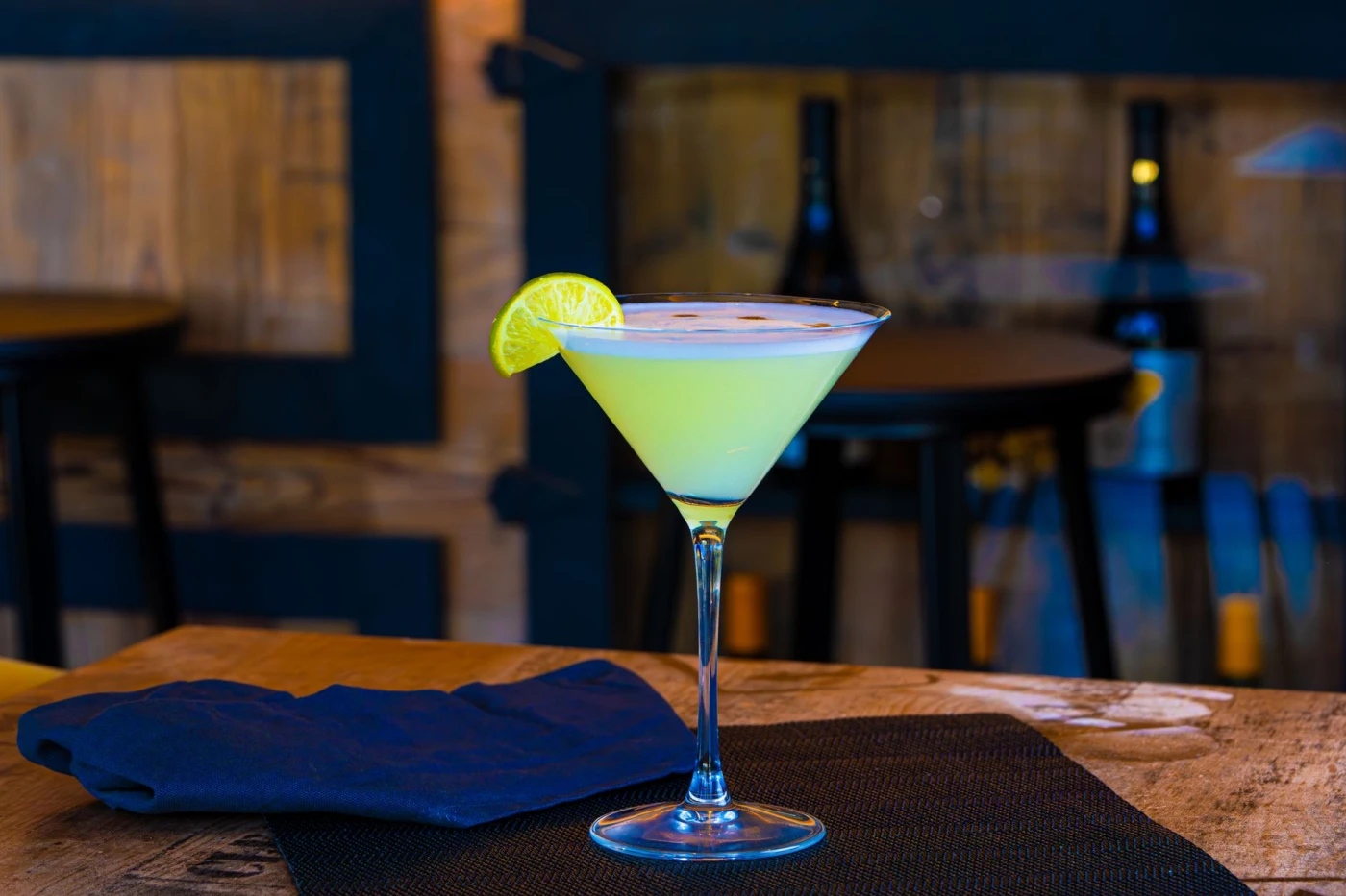 Absinthe Sour ingredients with cocktail bottle and bar tools