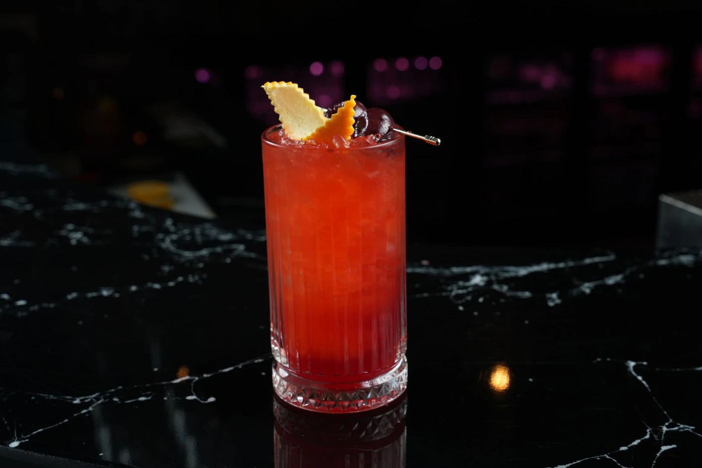 Achilles Heel ingredients with cocktail bottle and bar tools