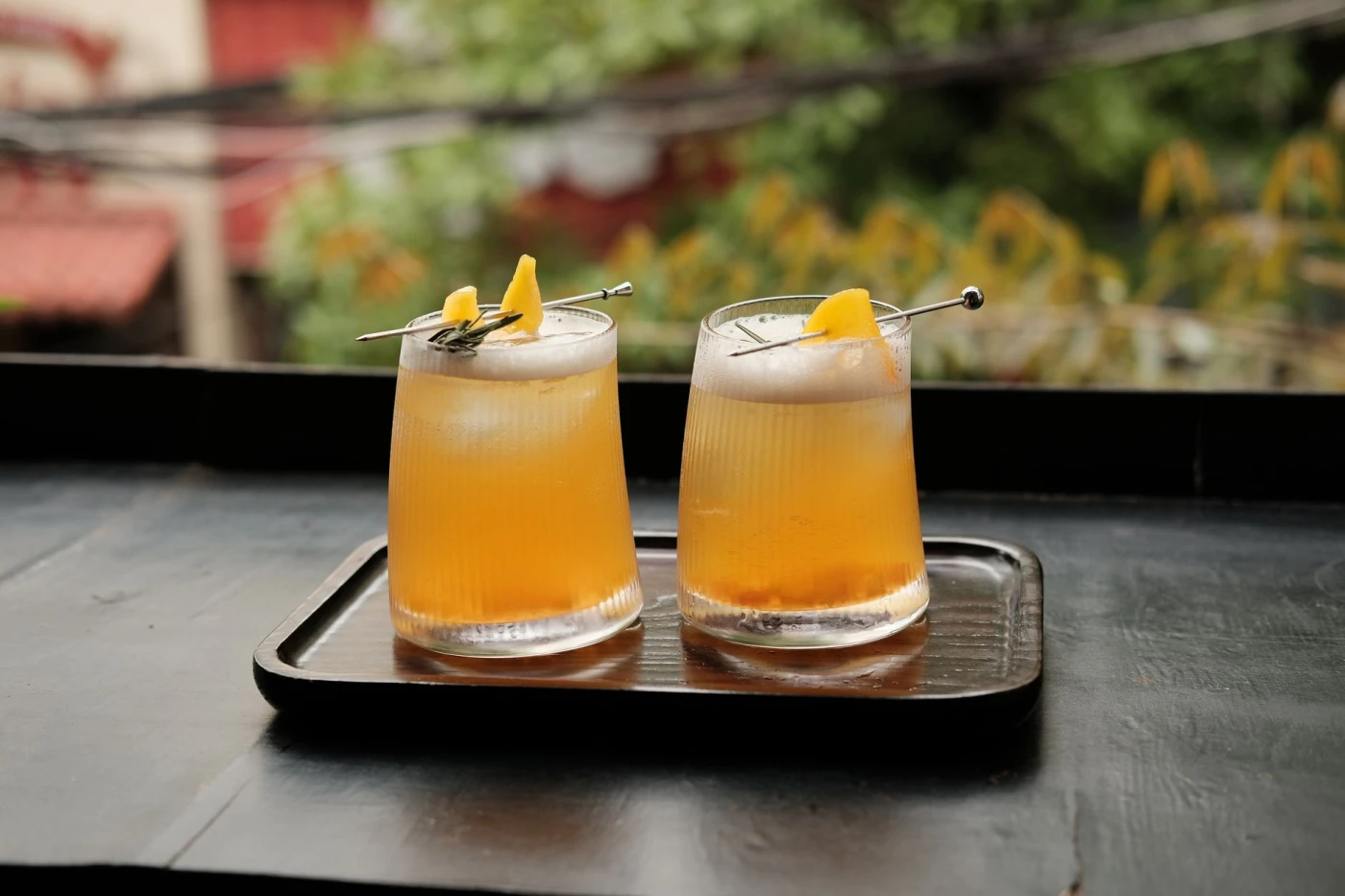 Alabama Slammer cocktail variations ingredients with cocktail bottle and bar tools