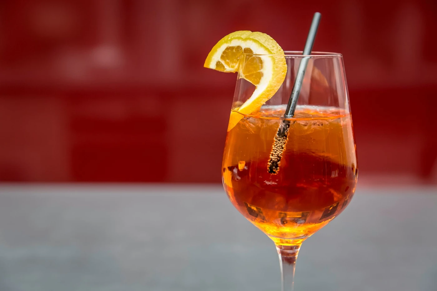 Aperol Spritz Pops: Bright Aperol spritz with lemon slice on a glass, perfect for summer refreshment.