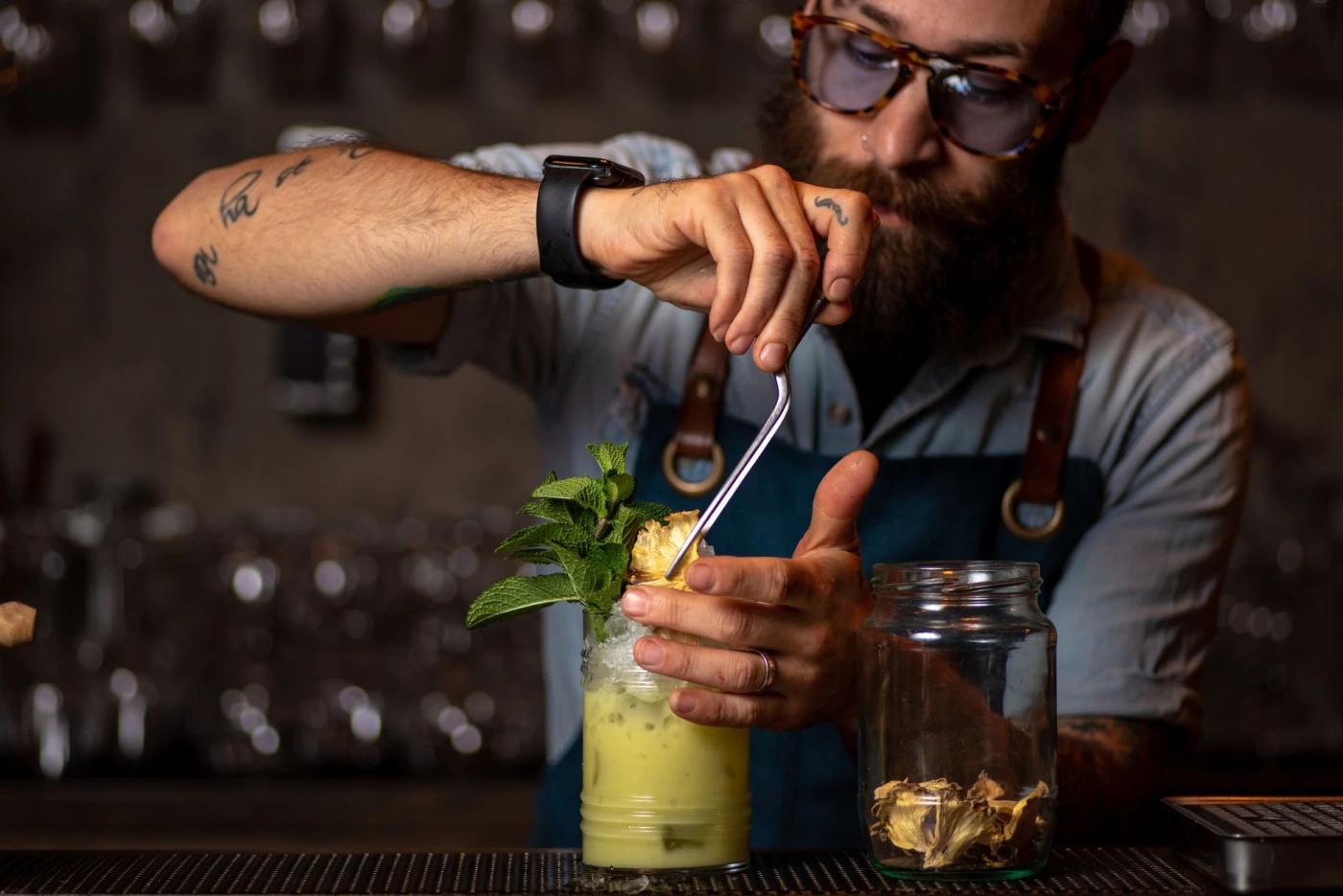 Bartender preparing a refreshing spiced rum and pineapple cocktail with mint garnish
