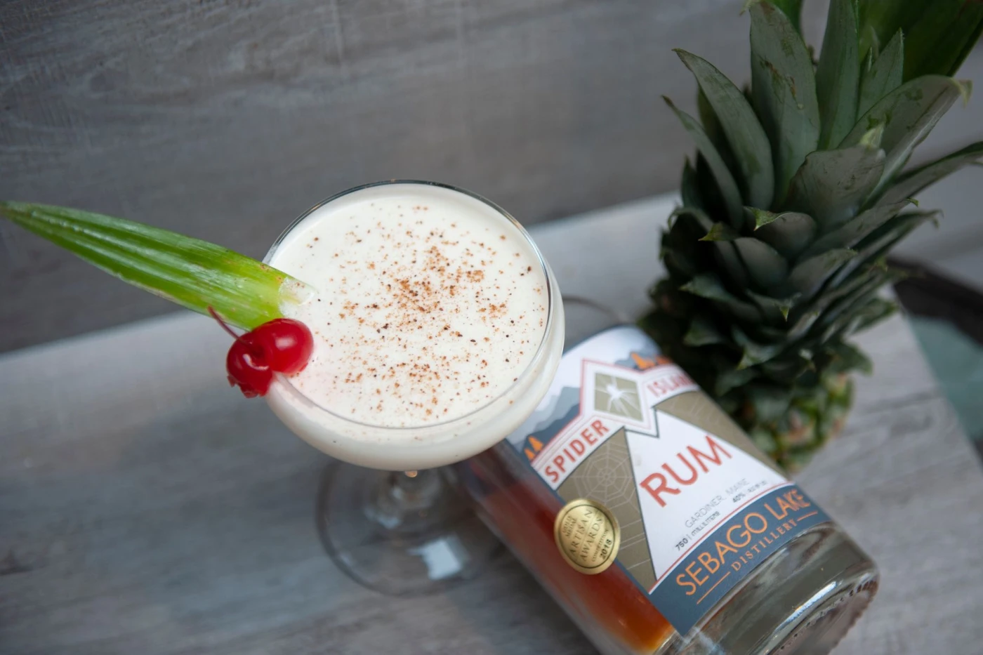 Spiced pineapple rum punch served over ice in a cocktail glass