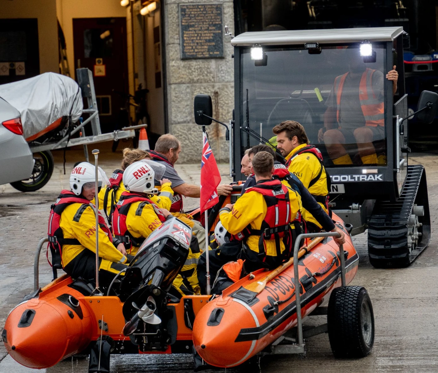 Rescue Team: Rescue team in lifejackets ready an inflatable boat at a station. Daytime scene.