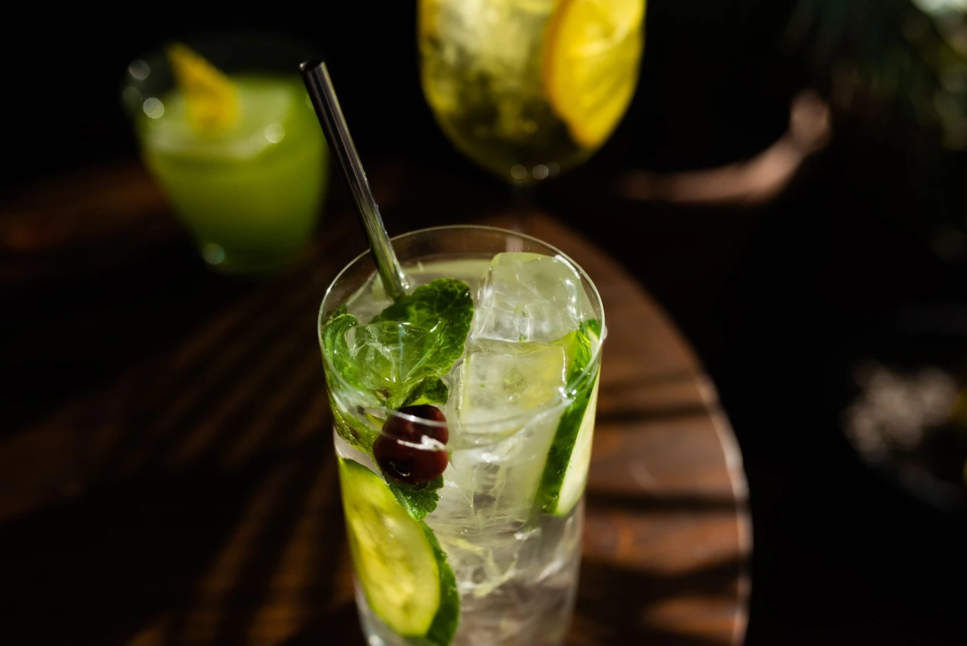 The 7 Clear Ice Molds: Close-up of a refreshing cocktail with mint, lime, and ice in a glass with a metallic straw.