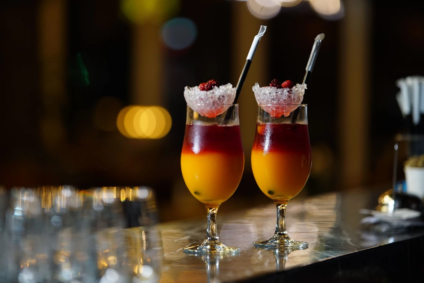 The 7 Clear Ice Molds: Two vibrant cocktails with berries and ice, set in a stylish bar setting.