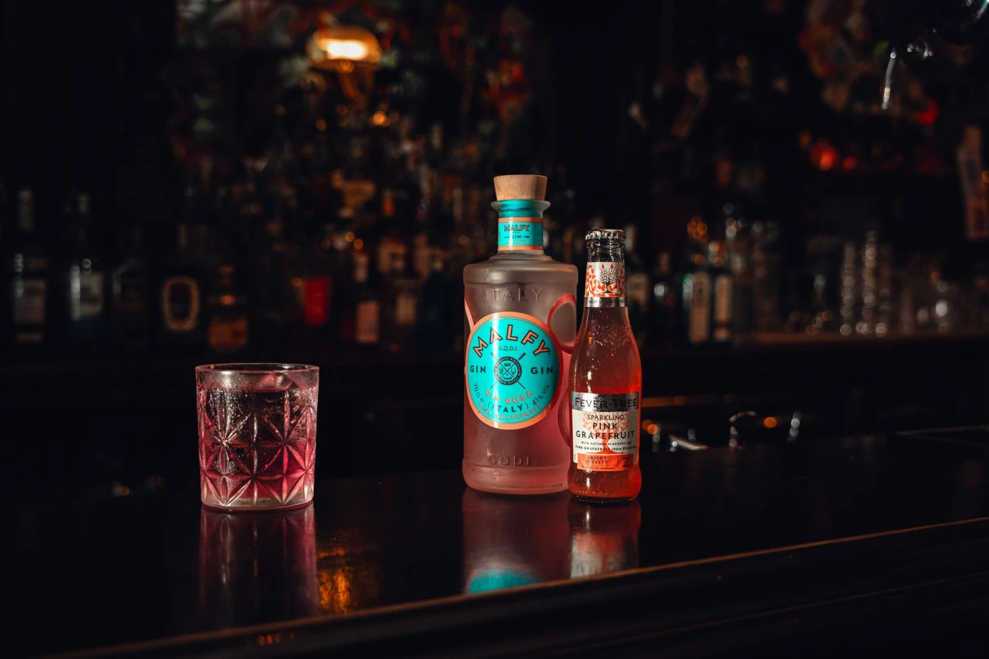 The History of Gin: Britain’s Own Spirit, Born of Chaos and Craft: Stylish display of gin, tonic, and cocktail glass in a dimly lit bar setting.