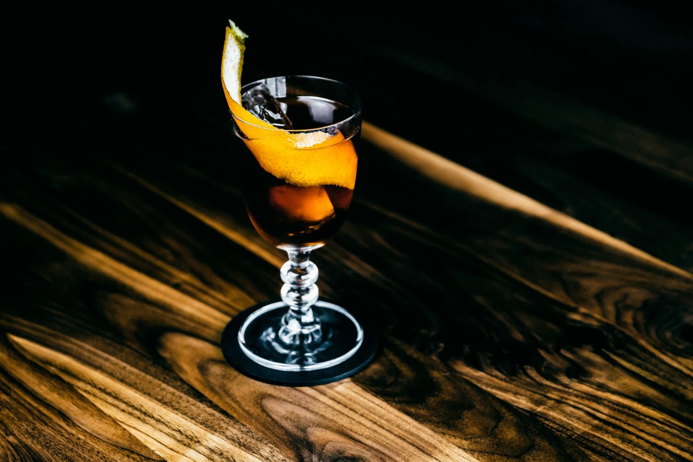 Bartender stirring a Tuxedo No. 2 cocktail over clear ice